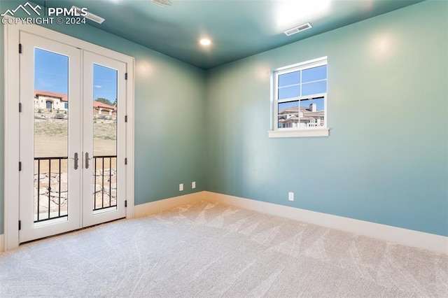 carpeted empty room featuring french doors