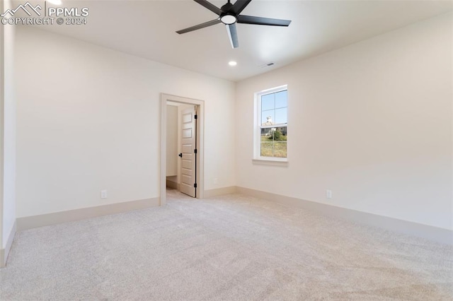 carpeted spare room featuring ceiling fan