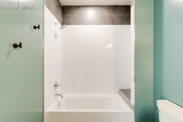 bathroom featuring tiled shower / bath and toilet