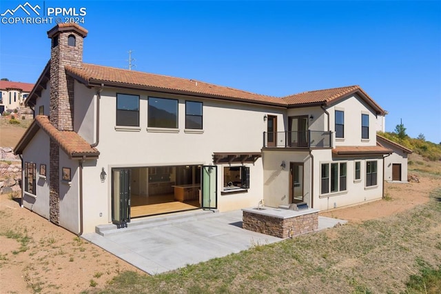 rear view of house with a balcony and a patio area