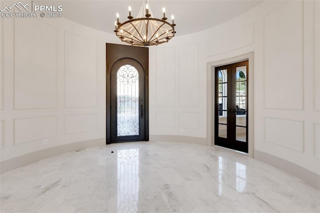 entrance foyer featuring a wealth of natural light, french doors, and a chandelier