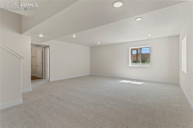 carpeted spare room with a textured ceiling