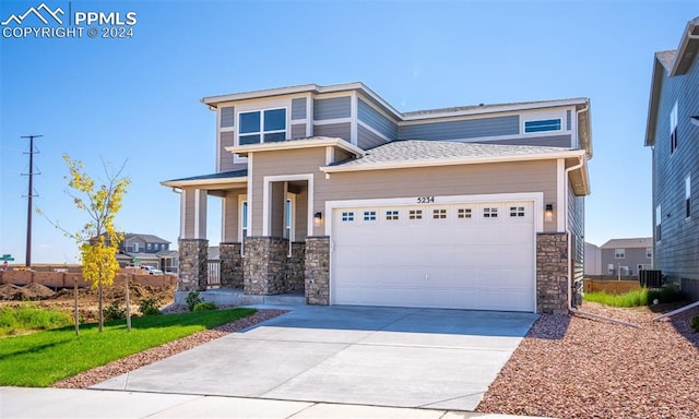 view of front of property with a garage and central AC