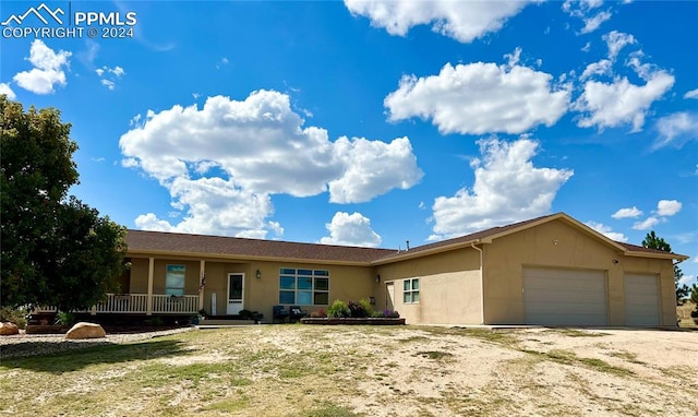 single story home featuring a garage and a porch