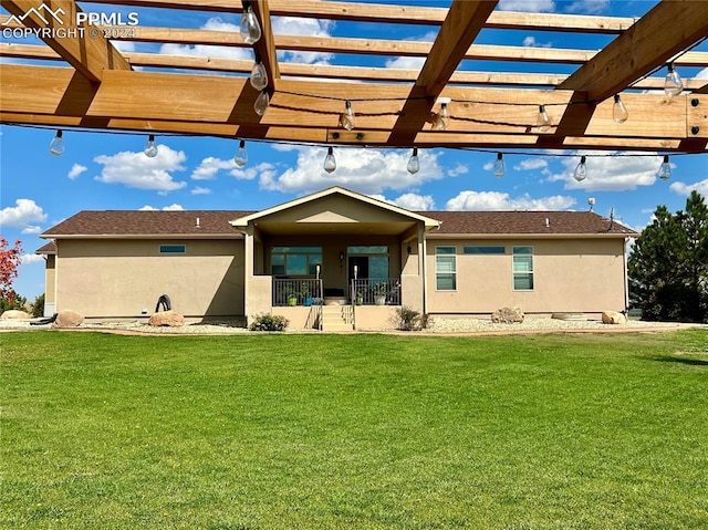 back of house featuring a yard and a pergola