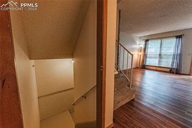 stairs featuring hardwood / wood-style floors and a textured ceiling