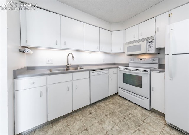 kitchen with a textured ceiling, sink, white appliances, and white cabinets