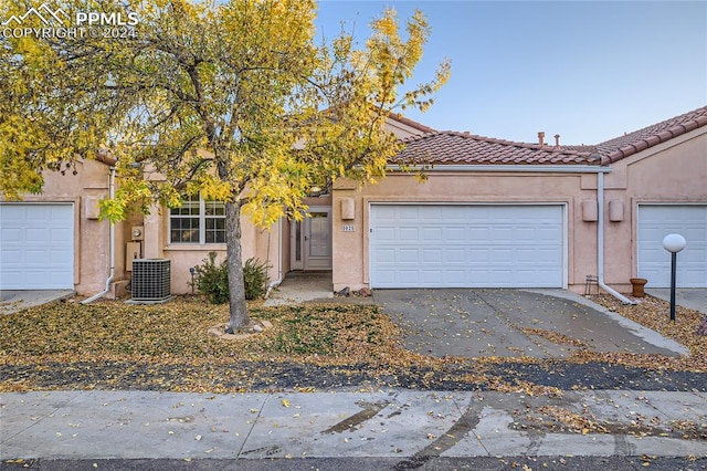 view of front of property featuring central AC unit and a garage