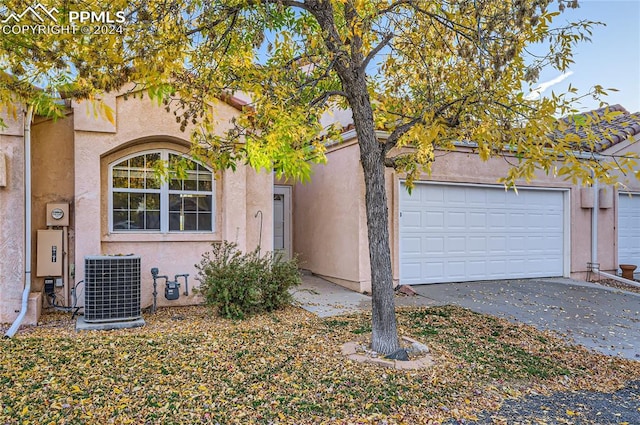 view of front of house featuring a garage and central AC