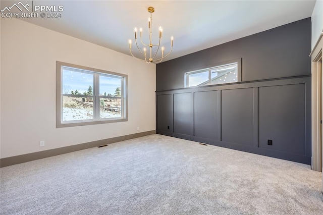 interior space featuring light carpet, an inviting chandelier, and multiple windows