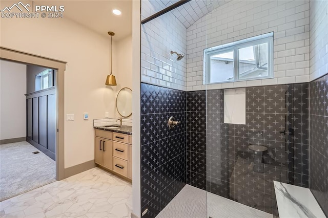 bathroom with tiled shower and vanity