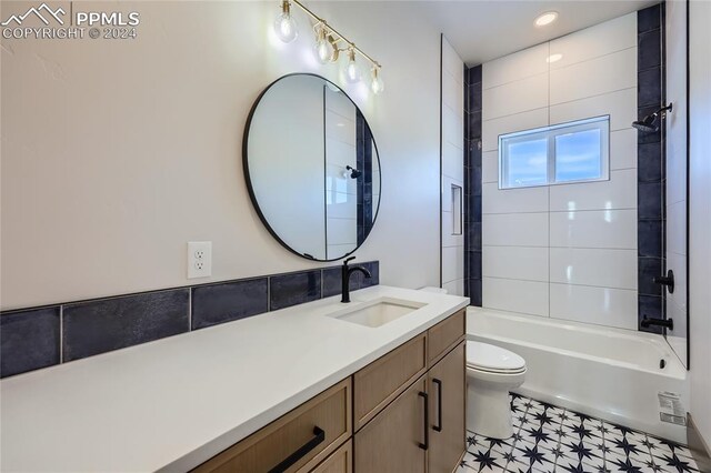 full bathroom with vanity, tiled shower / bath combo, and toilet