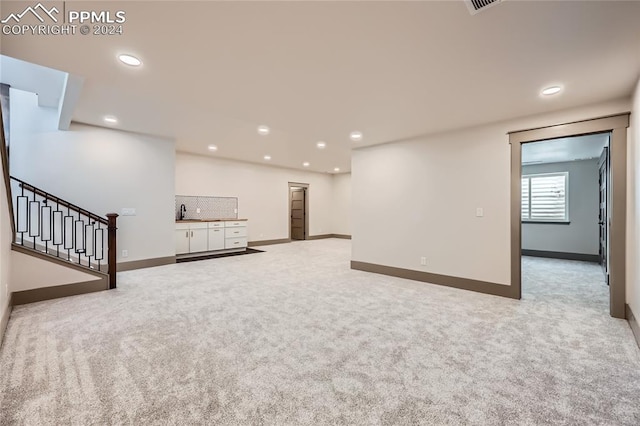 basement with light colored carpet and sink