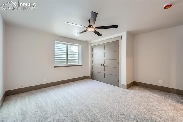 unfurnished bedroom featuring carpet flooring, ceiling fan, and a closet