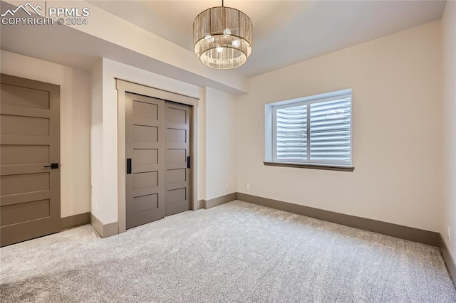 carpeted foyer with a chandelier