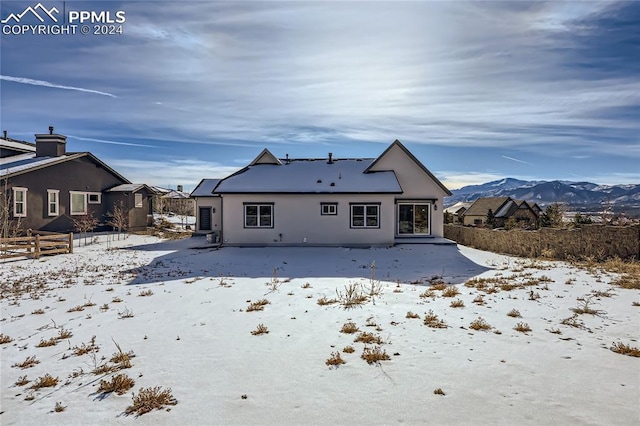 snow covered house featuring a mountain view