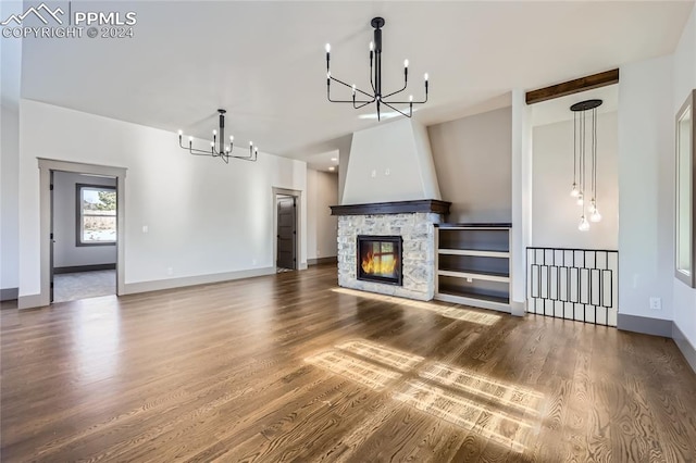 unfurnished living room featuring a fireplace, a chandelier, and dark hardwood / wood-style floors