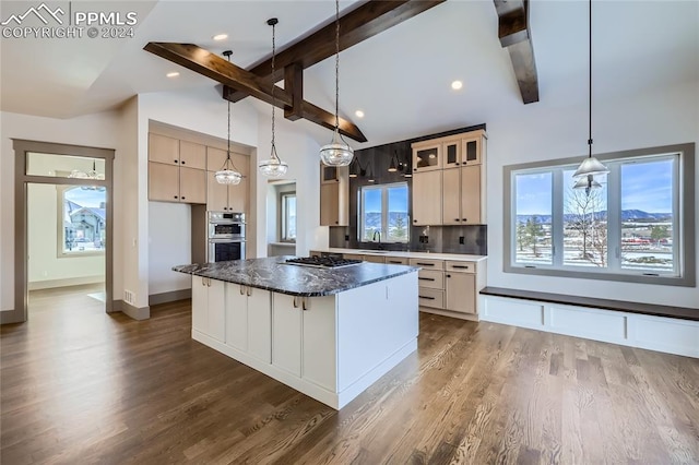 kitchen with dark hardwood / wood-style flooring, a center island, decorative light fixtures, and sink