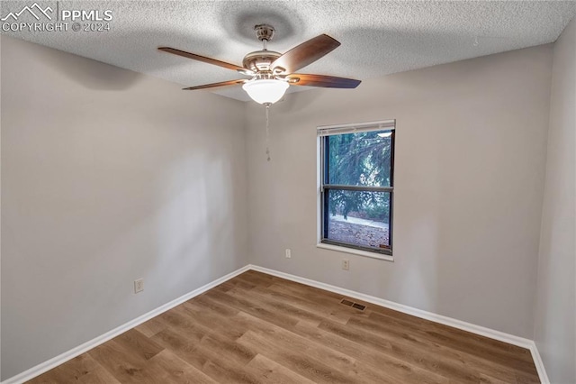 empty room featuring wood-type flooring, a textured ceiling, and ceiling fan