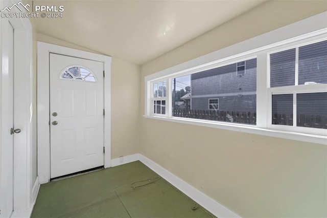 entrance foyer with lofted ceiling and concrete flooring