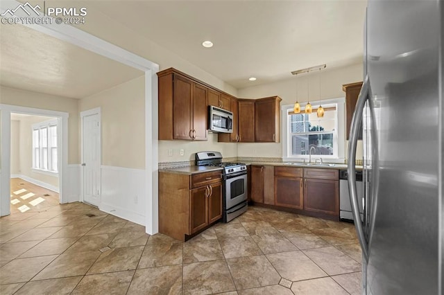 kitchen featuring decorative light fixtures, appliances with stainless steel finishes, light tile patterned floors, and sink