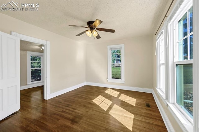 empty room featuring ceiling fan, dark hardwood / wood-style flooring, and a textured ceiling