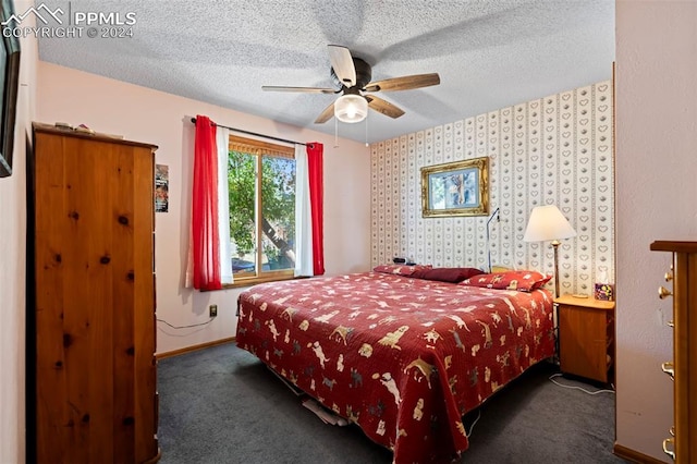 bedroom featuring dark colored carpet, ceiling fan, and a textured ceiling