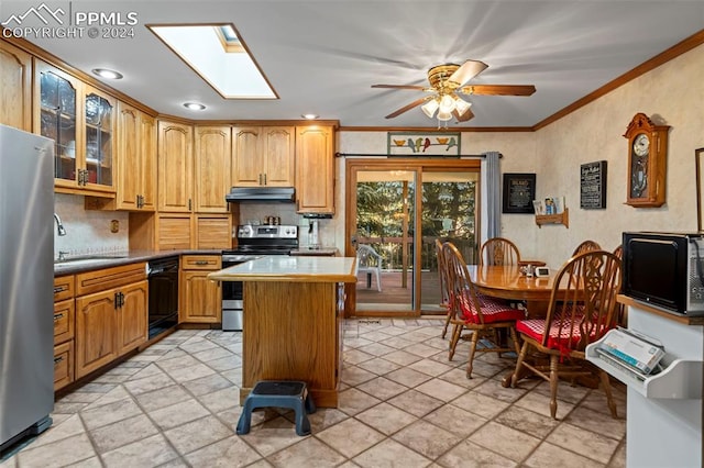 kitchen featuring sink, a kitchen island, a skylight, appliances with stainless steel finishes, and ceiling fan