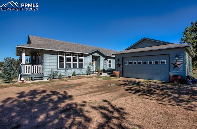 ranch-style house with a garage and covered porch