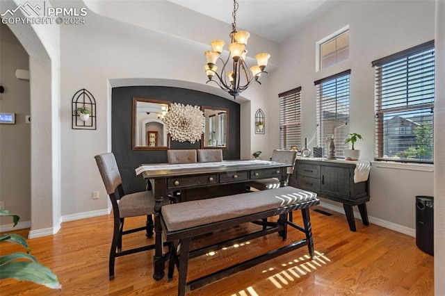 dining room with light hardwood / wood-style flooring and a chandelier