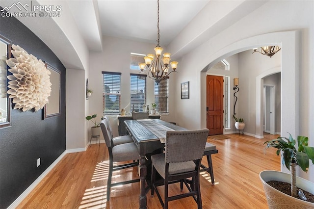 dining space featuring light wood-type flooring and a chandelier