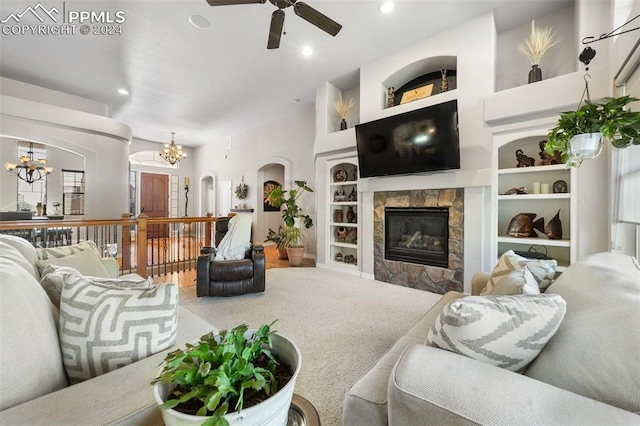 carpeted living room featuring ceiling fan with notable chandelier and built in features