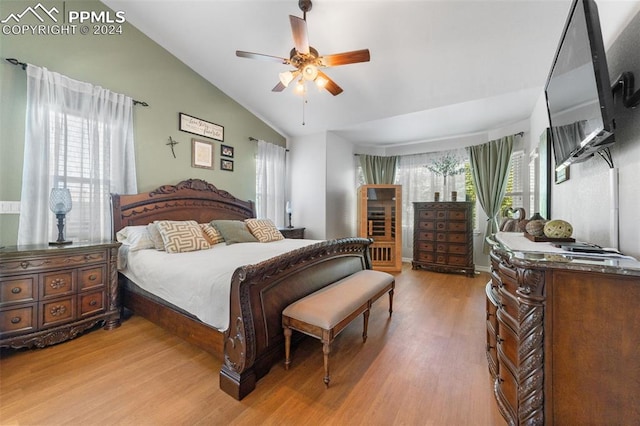 bedroom with ceiling fan, light wood-type flooring, and vaulted ceiling