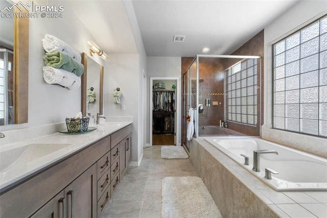 bathroom featuring tile patterned flooring, independent shower and bath, and vanity