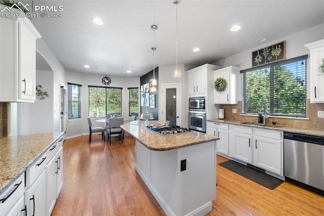 kitchen with a kitchen island, white cabinetry, sink, and stainless steel appliances