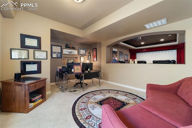 office area with a raised ceiling and carpet flooring