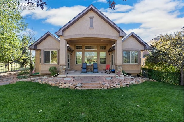 back of house with a yard and a patio