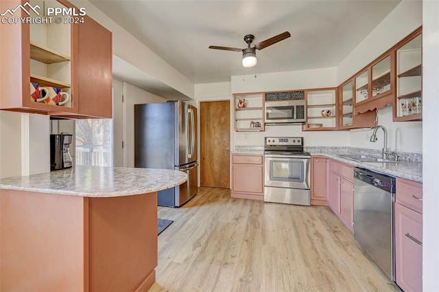 kitchen with ceiling fan, sink, kitchen peninsula, appliances with stainless steel finishes, and light wood-type flooring