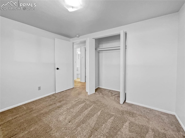 unfurnished bedroom featuring carpet flooring and a closet