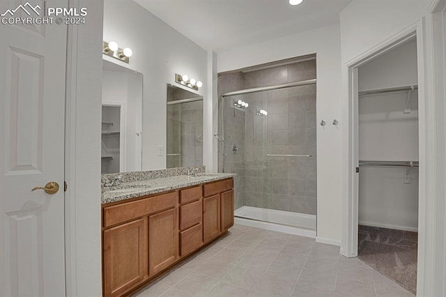 bathroom featuring vanity, a shower with door, and tile patterned floors