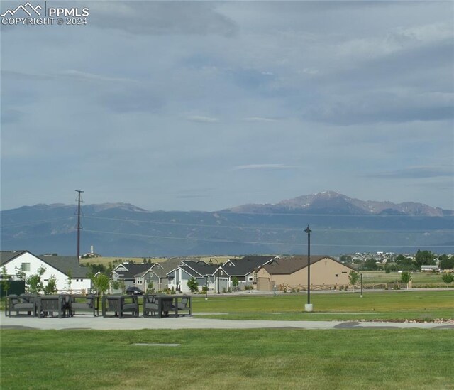 view of community with a mountain view and a yard