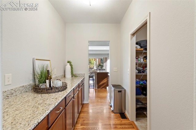 kitchen with light wood-type flooring and light stone counters