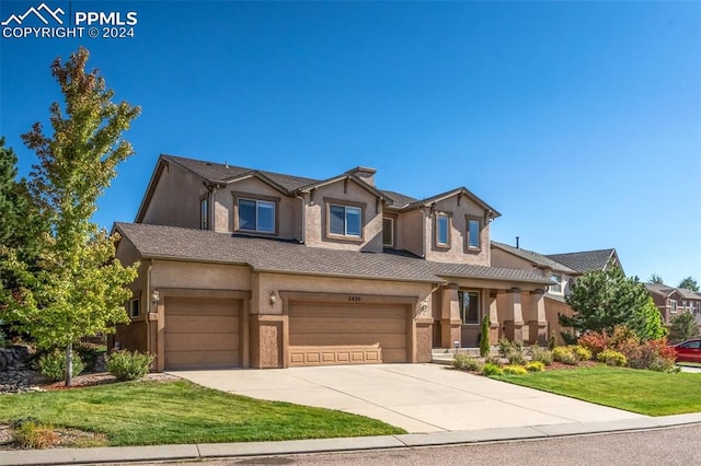 view of front of home with a front yard and a garage