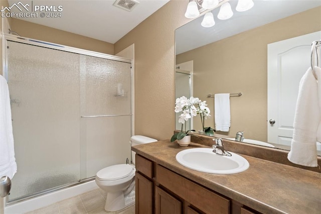 bathroom with vanity, tile patterned flooring, toilet, and a shower with door