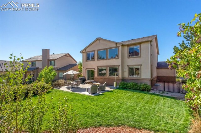 rear view of house with a yard and a patio area