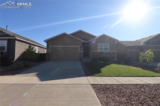 single story home with a garage and a front lawn