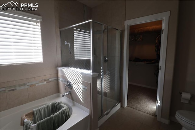 bathroom featuring plus walk in shower, tile patterned floors, and toilet