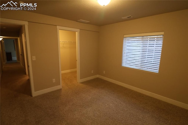 unfurnished bedroom with a walk in closet and a closet