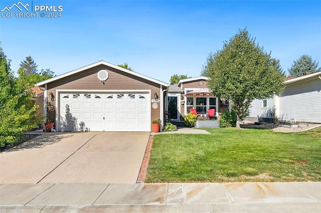 ranch-style house with a garage and a front lawn