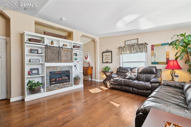 living room with lofted ceiling, a fireplace, and hardwood / wood-style floors